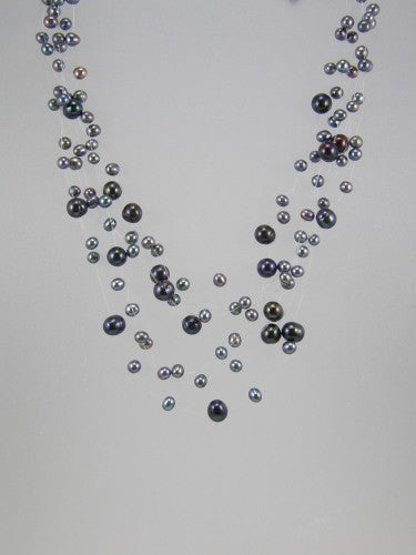 Mesh of grey fresh water pearls arranged on seven nylon strands and joined with a sterling silver clasp.