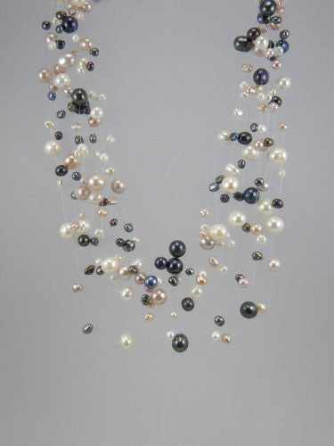 Mesh of grey, white and pink fresh water pearls arranged on fourteen nylon strands and joined with a sterling silver clasp.