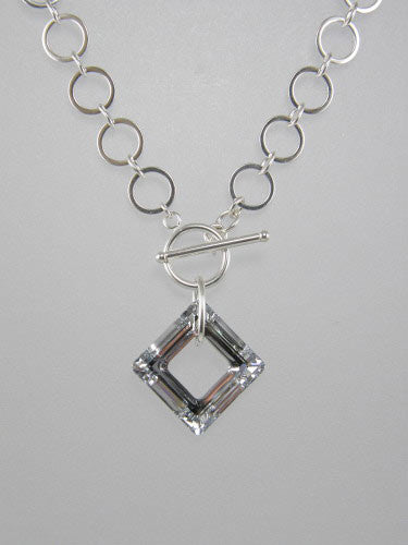 Sterling silver chain with 10 mm flat circle links and front toggle with silver square crystal ring pendant.