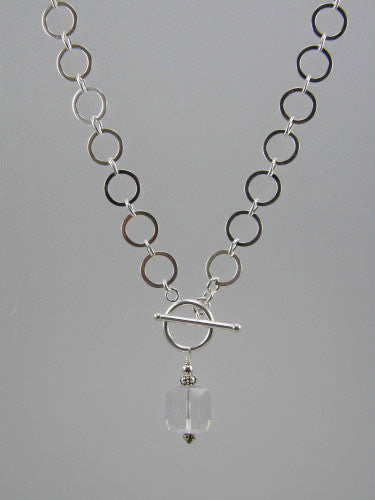 Sterling silver chain with 10 mm flat circle links and front toggle with 12 mm crystal cube pendant.