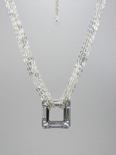 Flat round sterling silver chain triple-wrapped around 30 mm square silver crystal ring pendant.