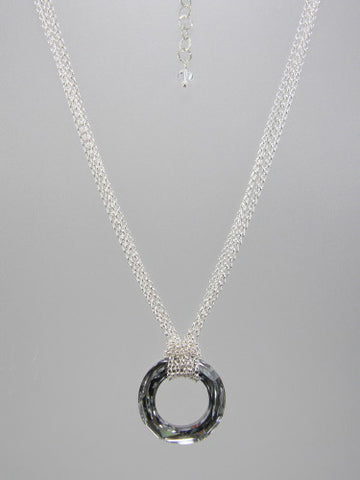 Fine round rolo link sterling silver chain layered and knotted around 30 mm round silver crystal ring pendant.